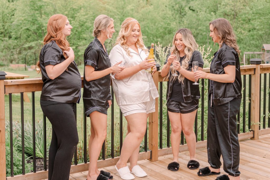 aiden laurette photography | group of women standing on a deck toasting with champagne