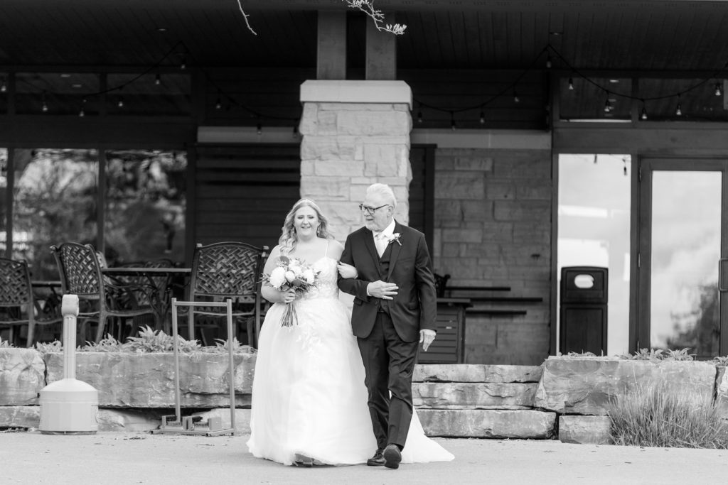 aiden laurette photography | black and white photo of bride and man standing in front of stone building
