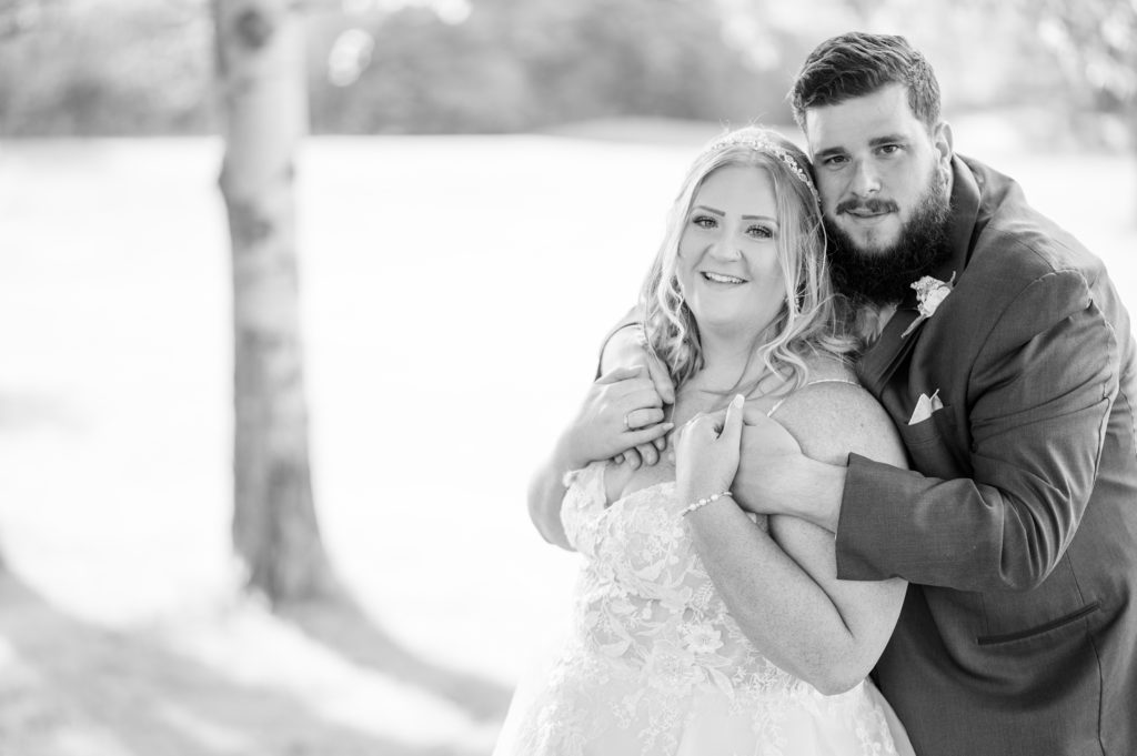 aiden laurette photography | bride and groom pose on grass in front of trees