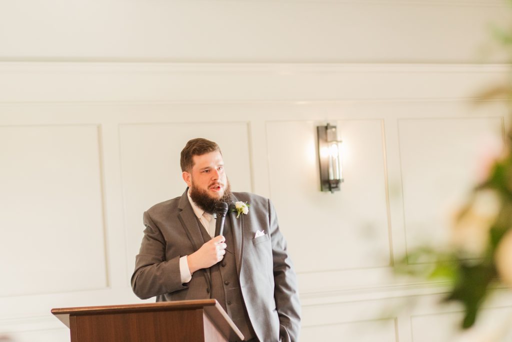 aiden laurette photography | bearded man stands at podium with microphone in his hand