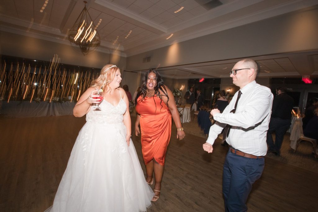 aiden laurette photography | bride dances with woman and man in formal wear