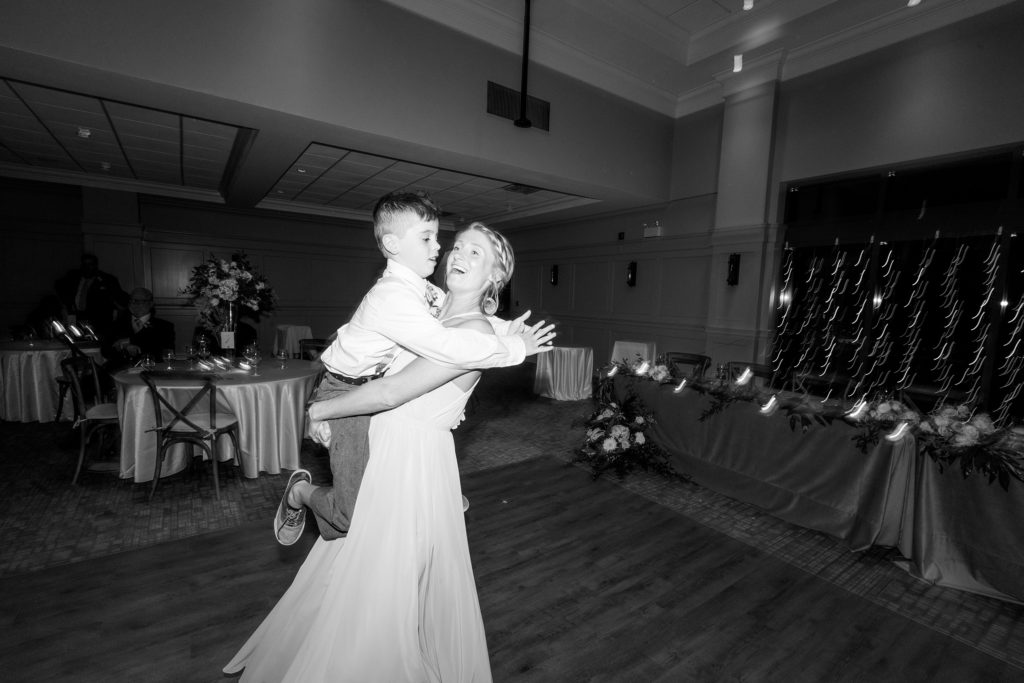 aiden laurette photography | black and white image of woman holding little boy on dancefloor