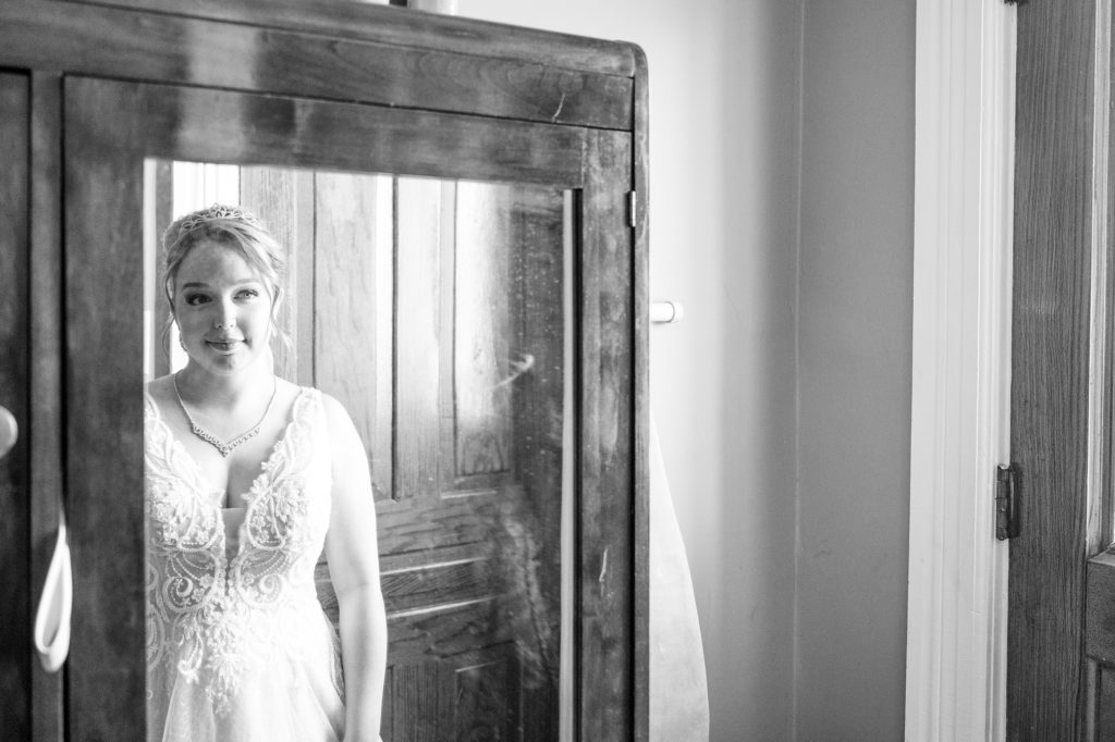 Aiden Laurette Photography | black and white photo of bride looking at her reflection in the mirror