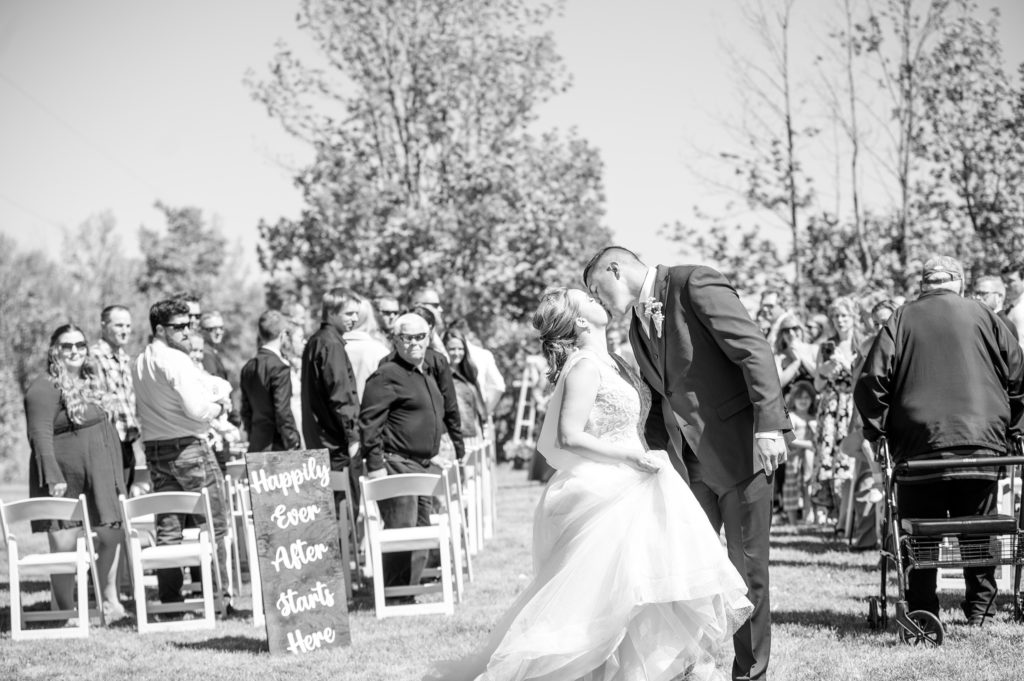 Aiden Laurette Photography | bride and groom kiss as wedding guests look on