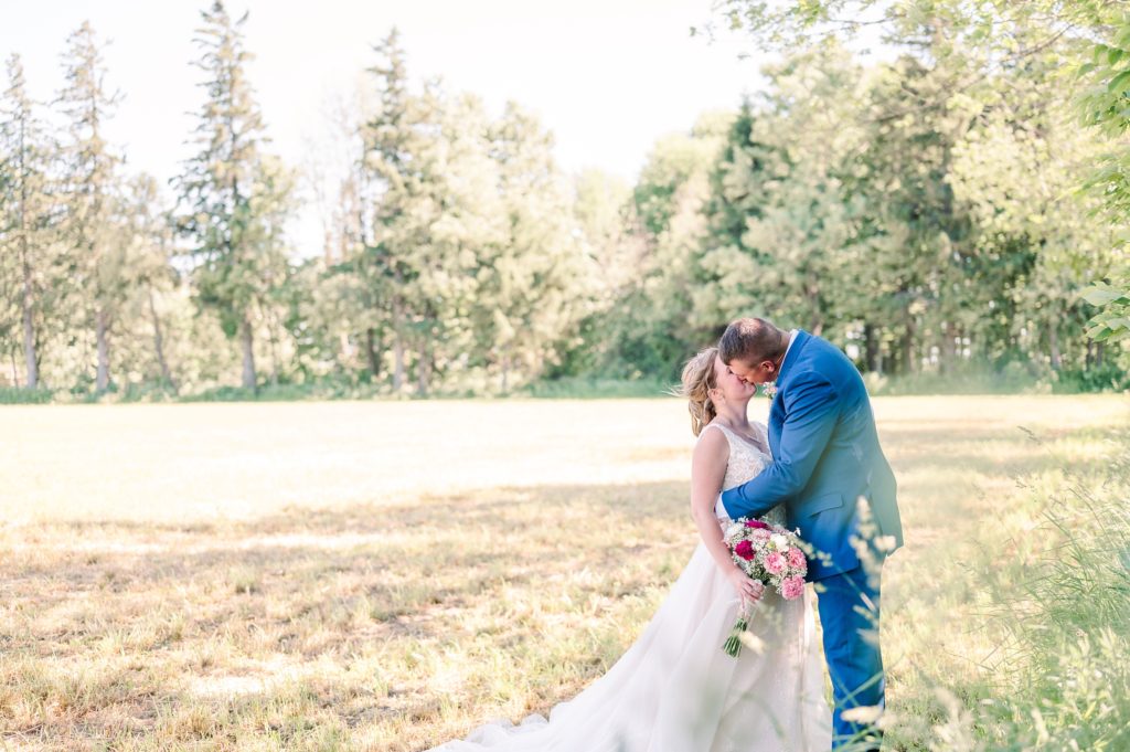 Aiden Laurette Photography | bride and groom kiss in field 