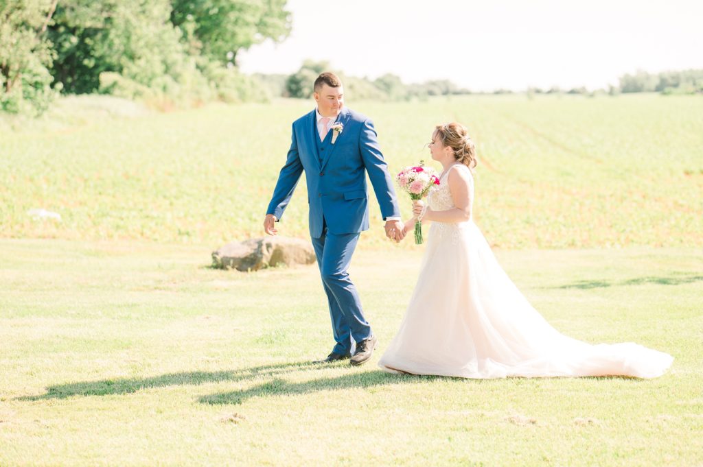 Aiden Laurette Photography | bride and groom walk in field