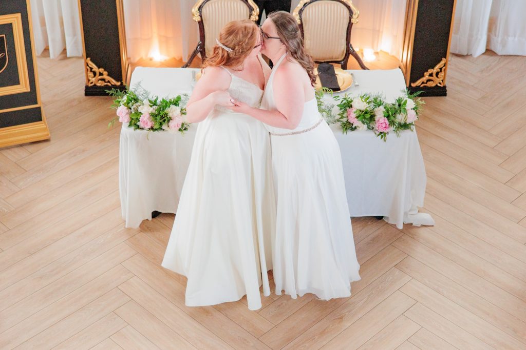 Aiden Laurette Photography | brides kiss on dancefloor in front of head table