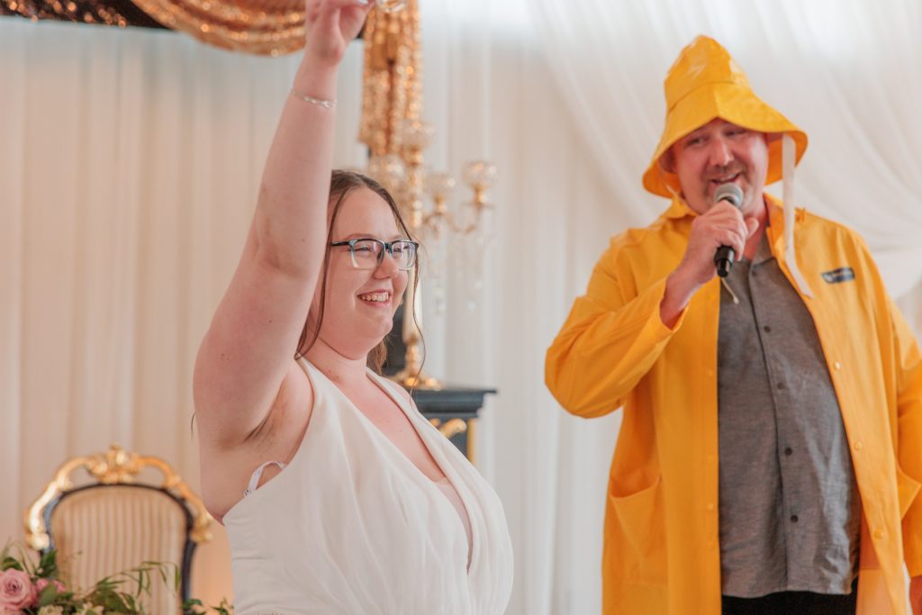 Aiden Laurette Photography |bride cheers next to main in yellow raingear