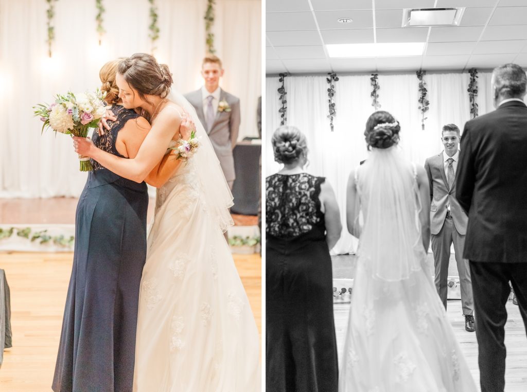 Aiden Laurette Photography | bride hugs woman in blue dress black and white photograph of bride standing in between man and woman while groom looks on 