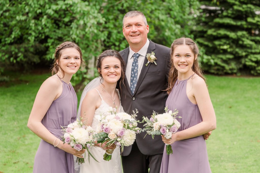Aiden Laurette Photography | man in formal wear poses with bride and women in purple dresses
