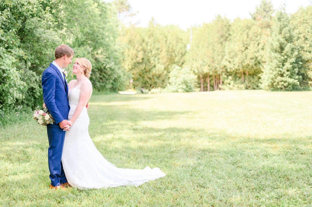 Aiden Laurette Photography | bride and groom pose in field