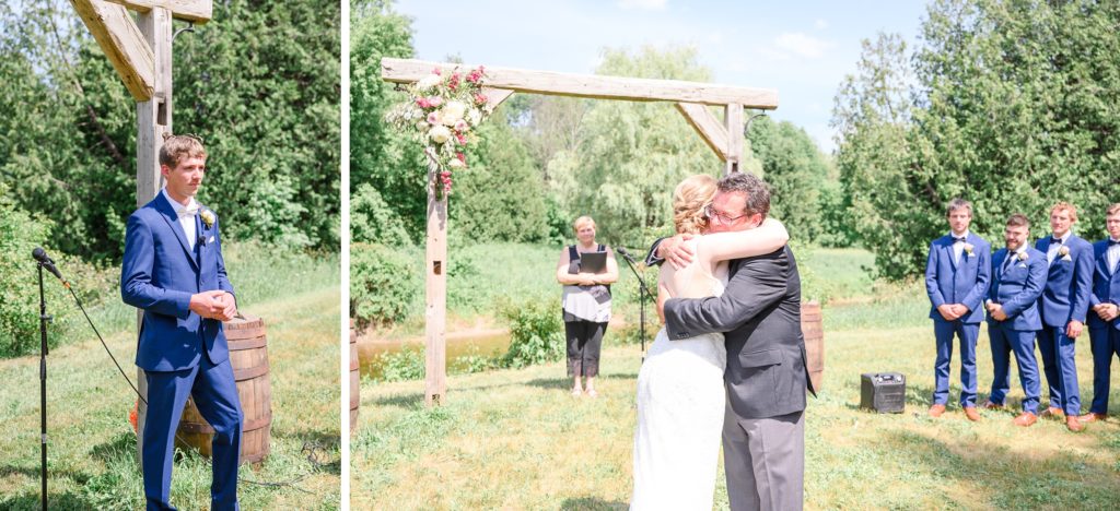 Aiden Laurette Photography | groom stands at alter; bride hugs man in suit at alter