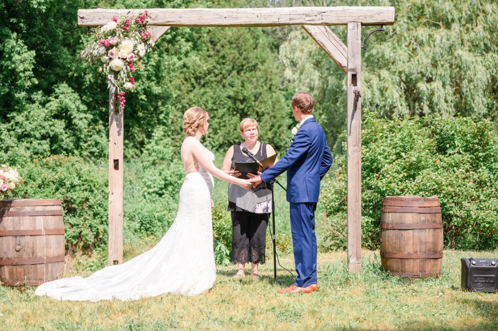 Aiden Laurette Photography | bride and groom hold hands in front of officiant