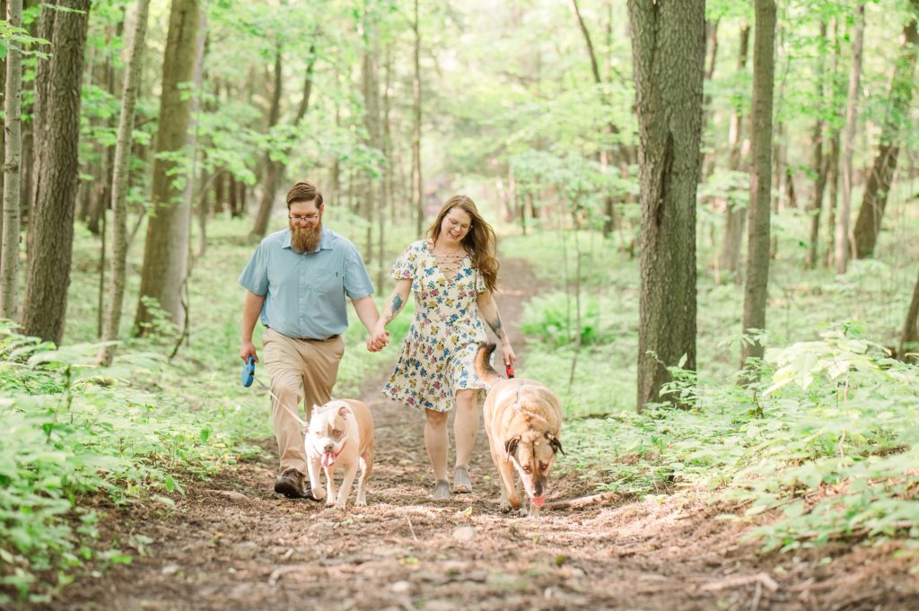 Aiden Laurette Photography | a man and woman walk their dogs in the woods