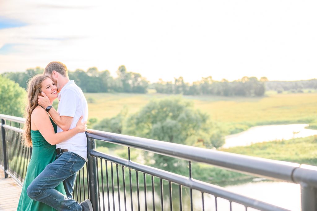 Aiden Laurette Photography | man and woman stand embracing on balcony rail