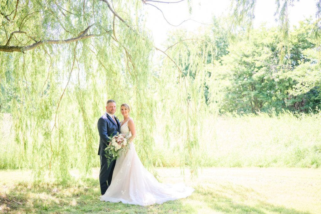 Aiden Laurette Photography | bride and groom stand under willow tree