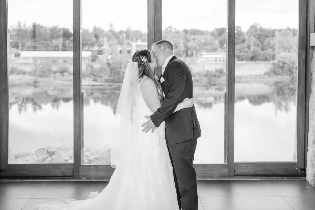 Aiden Laurette Photography | black and white photo of bride and grooms first kiss