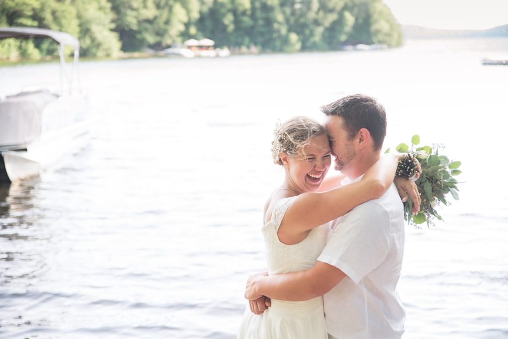 Aiden Laurette Photography | bride and groom pose in front of water