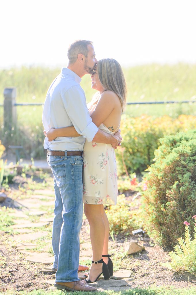 Aiden Laurette Photography | man kisses womans forehead in front of flowers