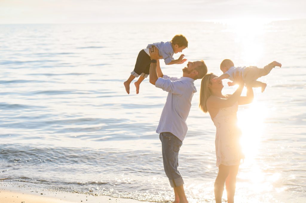Aiden Laurette Photography | engaged couple stand with toddler and infant on beach