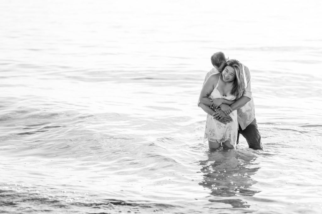 Aiden Laurette Photography | engaged couple stand in waves