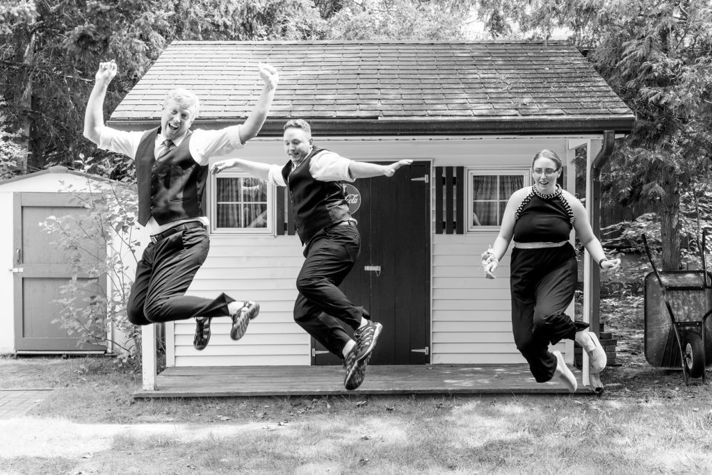 Aiden Laurette Photography | black and white photograph of wedding party jumping for joy
