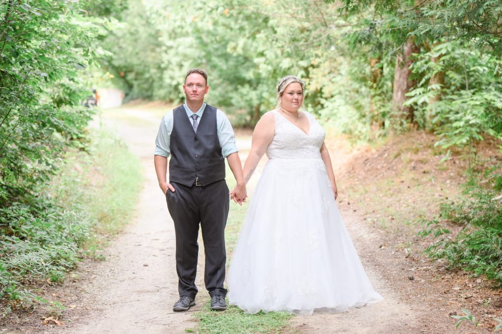 Aiden Laurette Photography | bride and groom stand on bridge surrounded by greenery