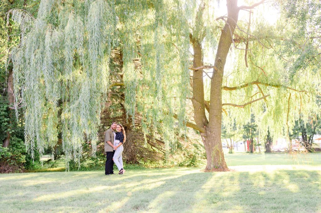 Aiden Laurette Photography | man and woman pose in front of willow trees