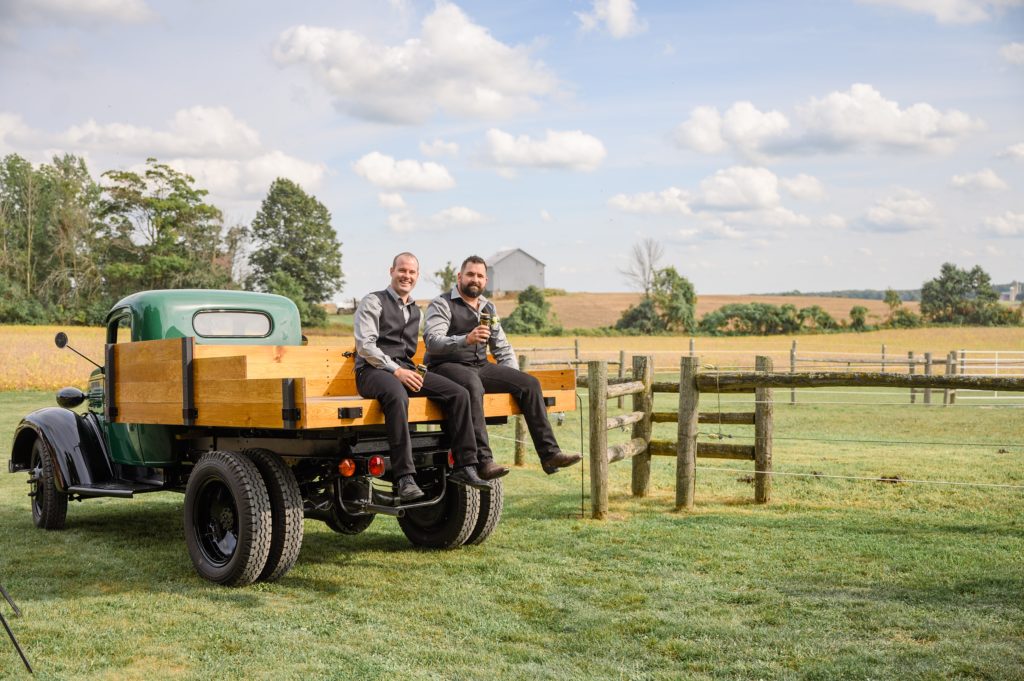 Aiden Laurette Photography | groom and groomsman pose on antique truck