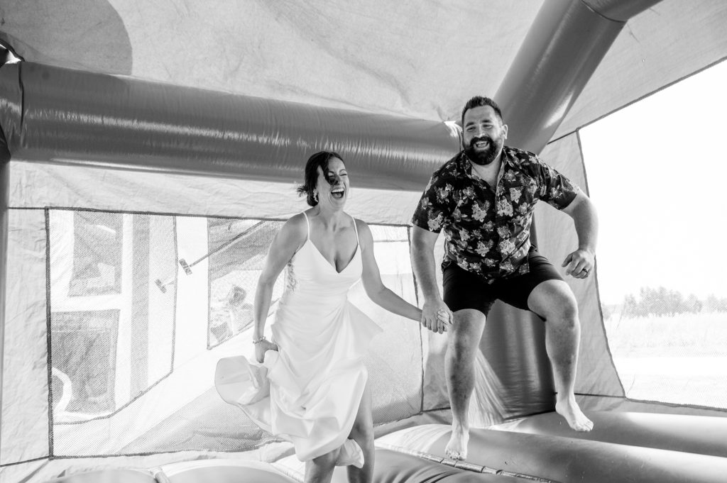 Aiden Laurette Photography | bride and groom pose bounce in bouncy castle