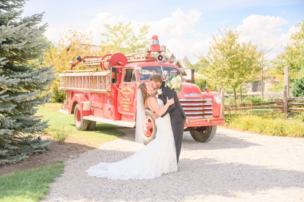 Aiden Laurette Photography | Bride and groom kiss in front of antique firetruck