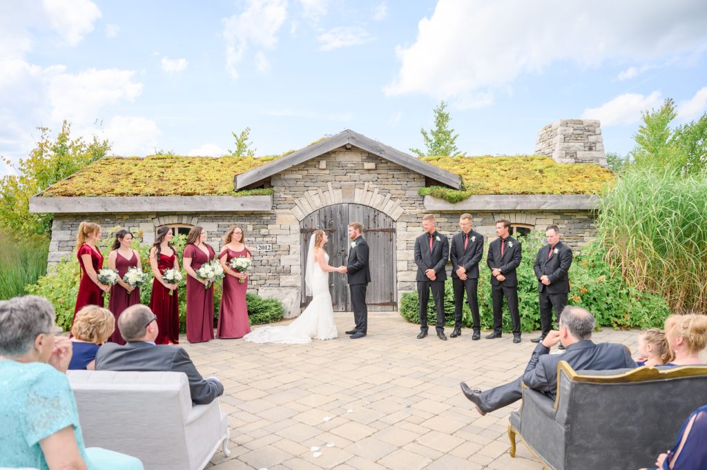 Aiden Laurette Photography | bride and groom stand at alter with wedding party as guests look on in hanover