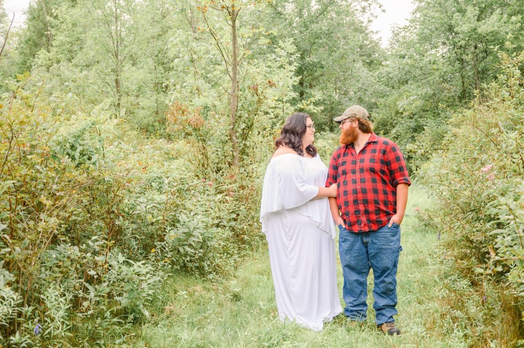 Aiden Laurette Photography | Woman in white dress and man in plaid shirt stand on path