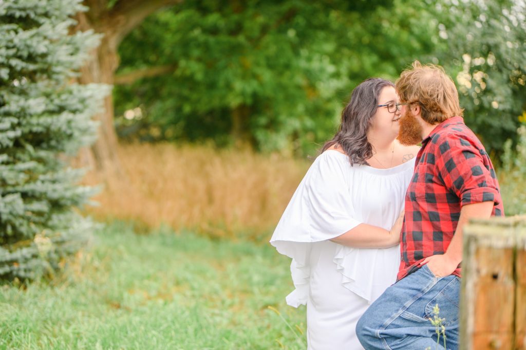 Aiden Laurette Photography | Woman in white dress and man in plaid shirt stand in field