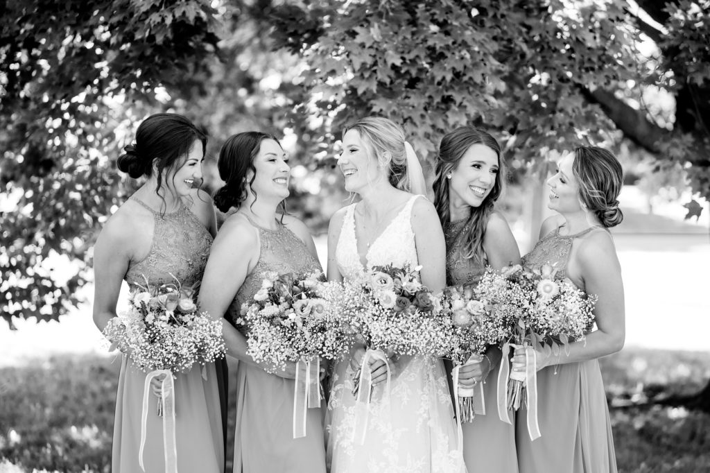 Aiden Laurette Photography | bride poses with bridesmaids under tree
