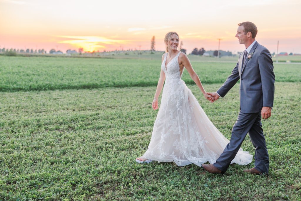 aiden laurette photography | bride and groom walk in field