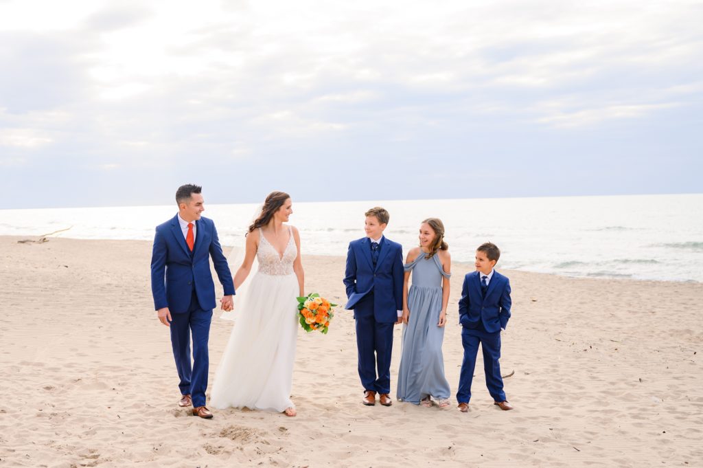 Aiden Laurette Photography | bride and groom walk with children on beach in grand bend