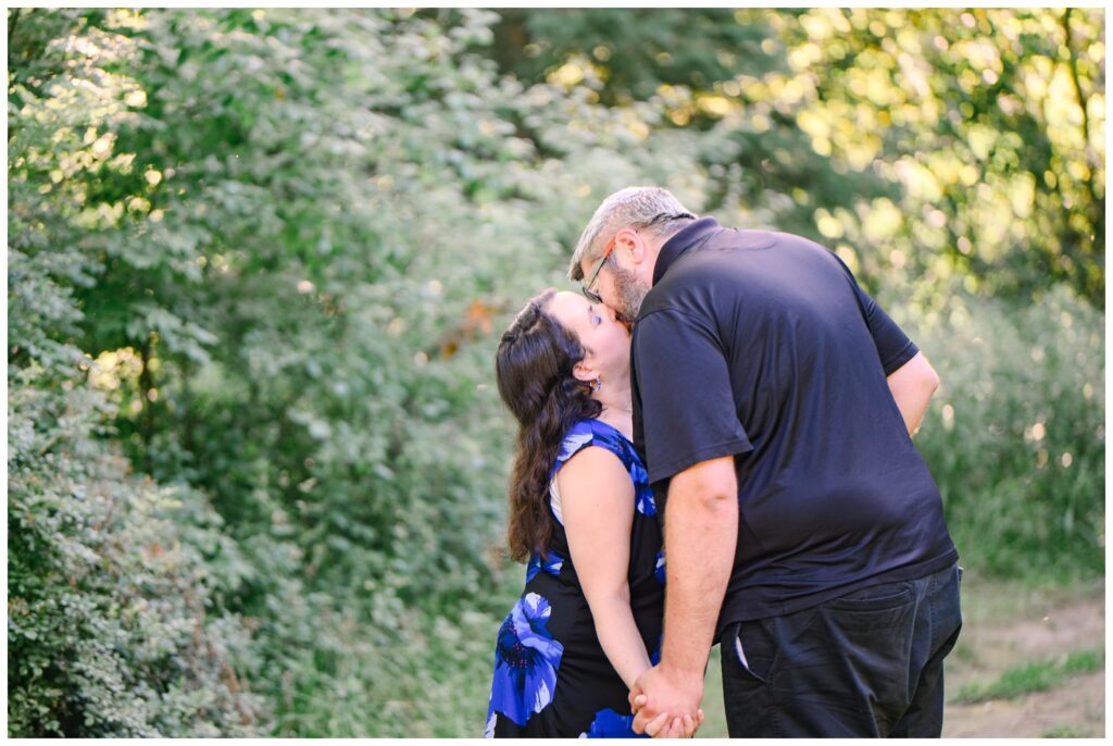 Aiden Laurette Photography | engaged couple kiss surrounded by greenery